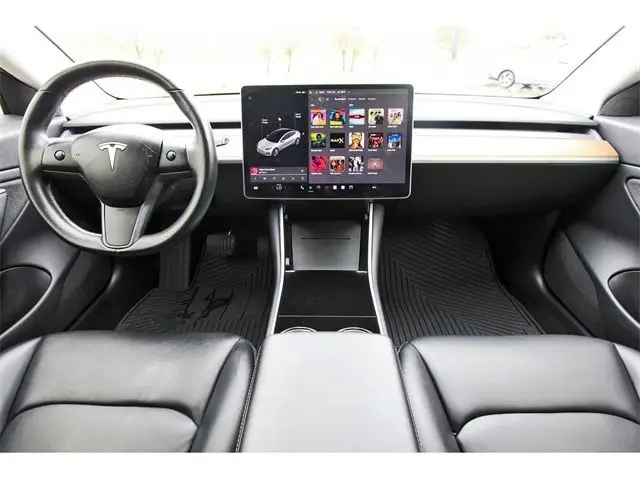 2018 Tesla Model 3 Long Range w_ Full Self Driving Capability - Engine Stories Tesla car interior showing sleek design with a touchscreen dashboard, black leather seats, and minimalist steering controls.