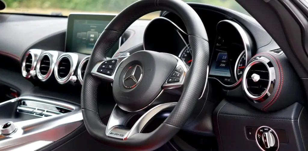 Car-Dashboard-Explained - Engine Stories Luxury car interior with Mercedes-Benz steering wheel, speedometer, and sleek dashboard design.