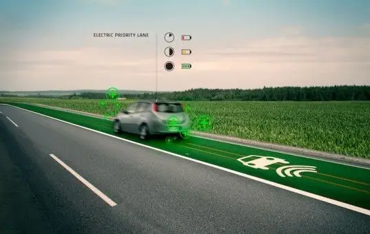 Life-Saving Smart Highways Can Charge Electric Vehicles on the Go - Engine Stories Electric car charging on priority lane in rural setting, showcasing green energy highway technology and sustainable innovation.