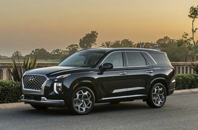 These Are the Best Affordable Family Cars in 2024 - Engine Stories Sleek black SUV parked outdoors at sunset, showcasing modern design and luxury features.