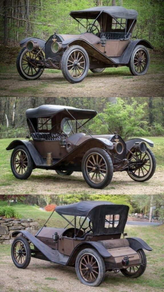 Vintage car with open-top design on a grassy area, showcasing classic early 20th-century automotive style.