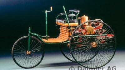 Vintage 1885 Daimler Reitwagen, early motor vehicle, green and brown with spoked wheels, showcasing automotive history.