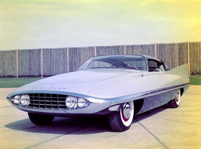 1956 Chrysler Dart by Ghia Concept car - Engine Stories Futuristic vintage concept car with sleek design, white and silver body, and distinctive front grille, parked outdoors.