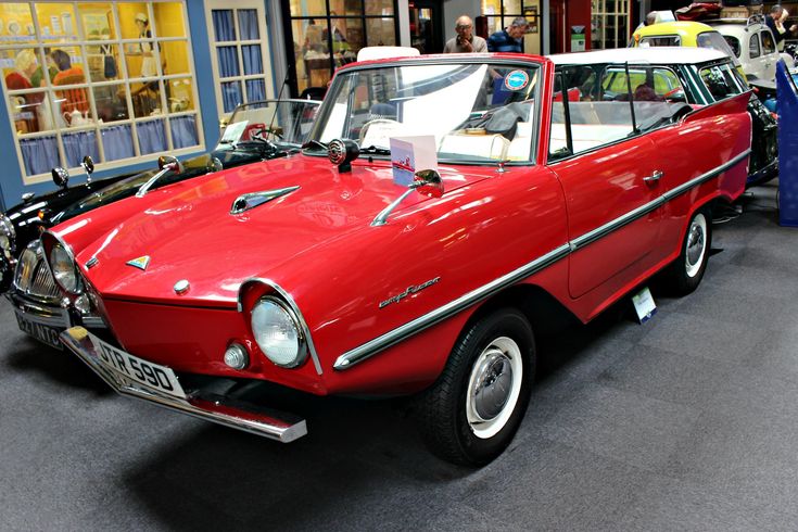 1960 Amphicar 770 - Engine Stories Red vintage amphibious car displayed in a museum, showcasing classic design and innovation.