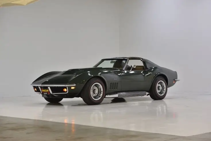 1969 Chevrolet Corvette L88 Coupe for Sale at Auction - Mecum Auctions - Engine Stories Classic dark green vintage sports car on display in a bright showroom.