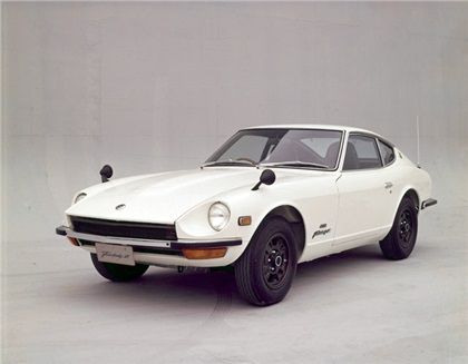 1969 Nissan Datsun 240Z Fairlady Z - Вехи - Engine Stories Classic white sports car with sleek design and vintage style from the 1970s, emphasized by smooth lines and prominent features.