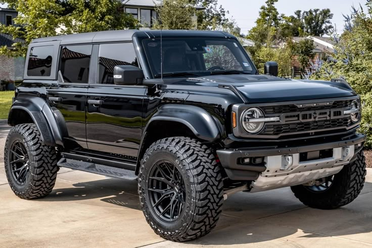 Sleek black off-road SUV parked outdoors, showcasing rugged tires and modern design.