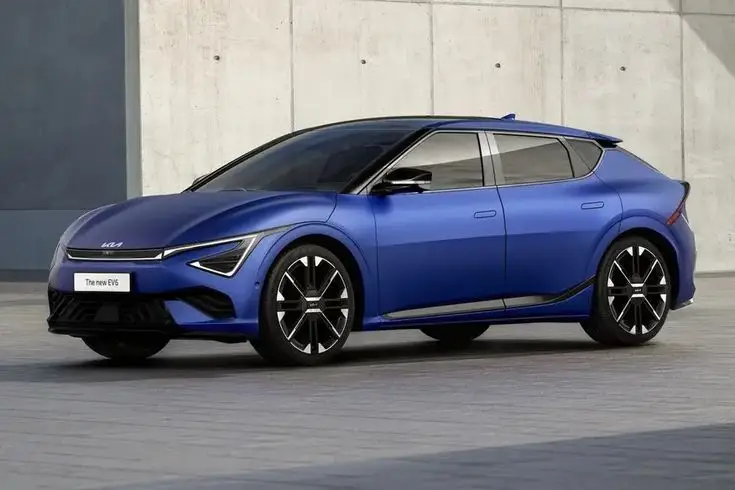 Sleek blue electric vehicle parked in front of a modern concrete wall, showcasing the latest in automotive design and innovation.