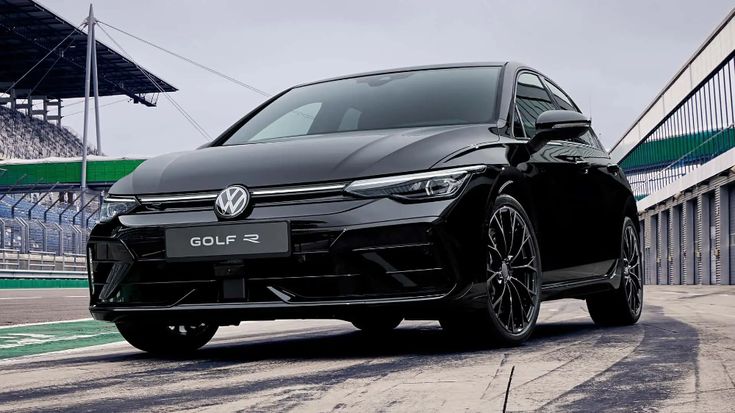 Sleek black Volkswagen Golf R parked on a race track, showcasing modern design and performance features.