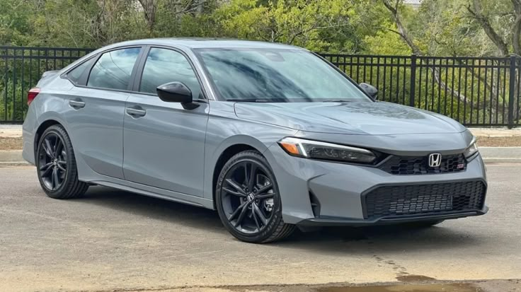 Sleek gray Honda Civic parked outdoors, showcasing modern design and black wheels on a sunny day.