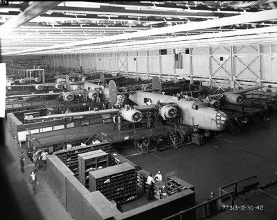 Assembly line of B-24 bombers in a 1940s factory, showcasing the aircraft production process during World War II.