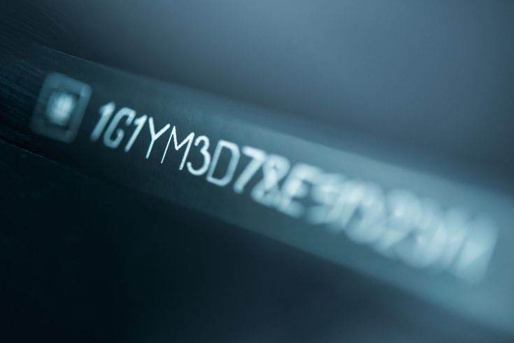 Close-up of a vehicle identification number (VIN) on a metal surface, illustrating automotive identification and security.