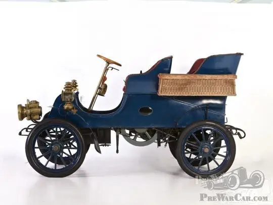 Car Cadillac Model A 1903 for sale - PreWarCar - Engine Stories Vintage blue car with brass details and wicker side, representing early automobile design.