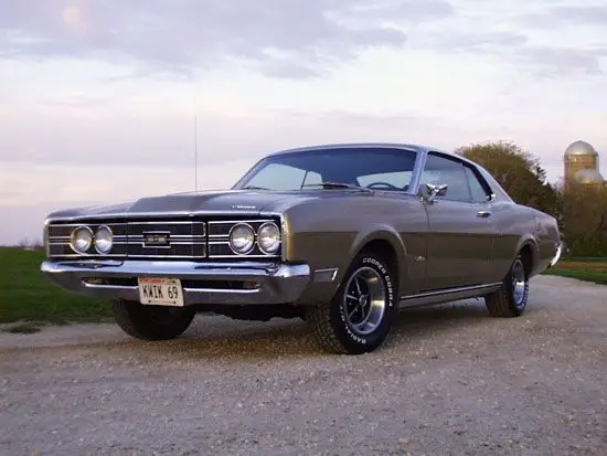Car of the Week_ 1969 Mercury Montego - Engine Stories Classic vintage car parked on a gravel road under a scenic sky, showcasing its sleek design and timeless appeal.