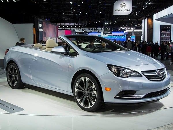 Class of 2016_ New Cars Ready to Roll - Kelley Blue Book - Engine Stories Silver convertible car showcased at an auto exhibition, surrounded by a crowd, under bright lighting and branded signs.