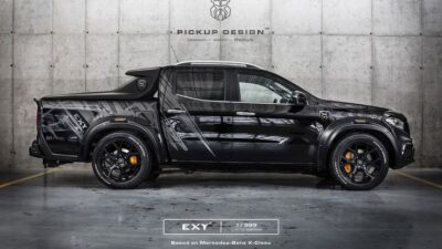 Customized black Mercedes-Benz X-Class pickup truck, side view, in an industrial setting. Luxurious and limited edition design.