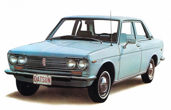 Datsun 510 - Engine Stories Vintage blue Datsun sedan showcasing classic automotive design with dual headlights and prominent grille.