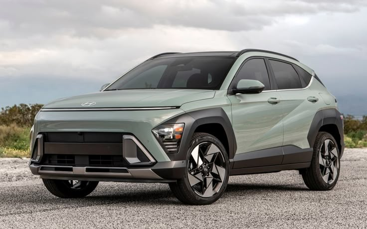 Sleek green crossover SUV on an empty road against a cloudy sky, highlighting modern design and advanced features.