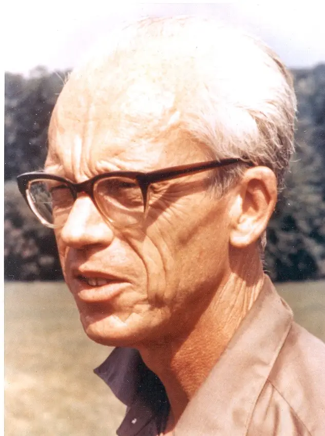 Ken Purdy - Engine Stories Elderly man with glasses and white hair outdoors on a sunny day, wearing a brown shirt.