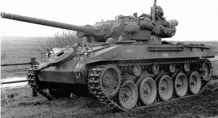 M18 Hellcat - Engine Stories Vintage military tank in a field, showcasing its large cannon and rugged tracks. Historical armored vehicle in black and white.