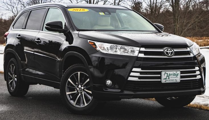 Toyota Highlander - Engine Stories Black 2018 SUV parked outdoors, showcasing its modern design and heritage dealership plate. Ideal for family travel and road trips.