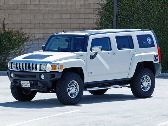 White Hummer H3 SUV parked outdoors on a sunny day, showcasing off-road capabilities and rugged design.