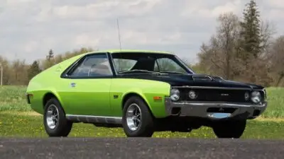 Vintage lime green and black classic car parked outdoors on a sunny day, showcasing sleek design and retro style.