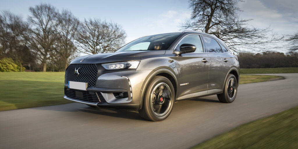 Sleek grey SUV driving on a scenic road, blending elegance with performance. Perfect for modern adventures.