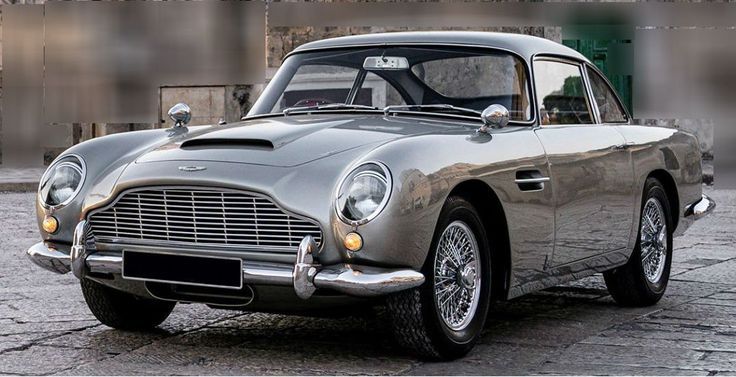 Classic silver sports car with chrome details parked on stone pavement, showcasing vintage elegance and timeless design.