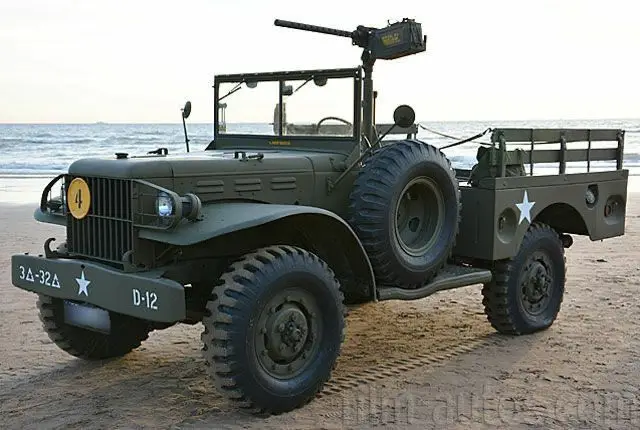 Vintage military vehicle on a beach, showcasing its rugged design and historical significance.