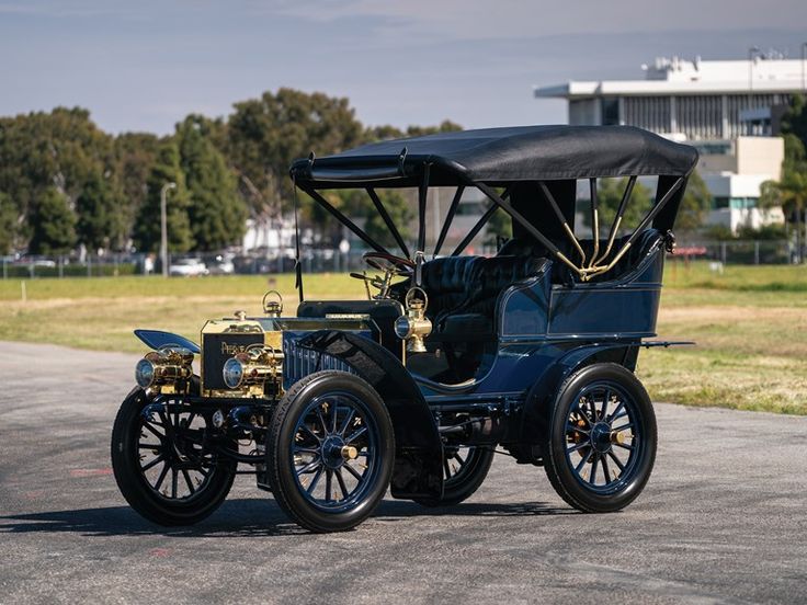 1904 Pierce Arrow _ Hershey 2019 _ RM Sothebys - Engine Stories Vintage blue brass-era car with open roof on outdoor street, showcasing classic early 20th-century automobile design.