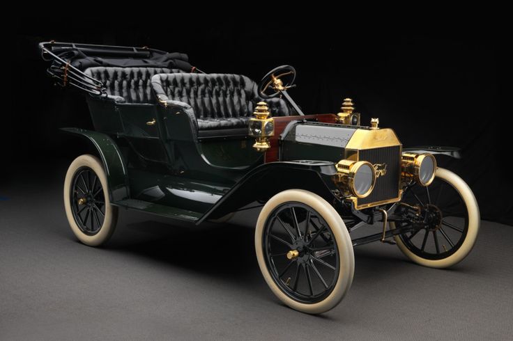 Ford Model T Touring 049 - Engine Stories Vintage Ford Model T car with brass fittings and black upholstery, showcasing classic early 20th-century automotive design.