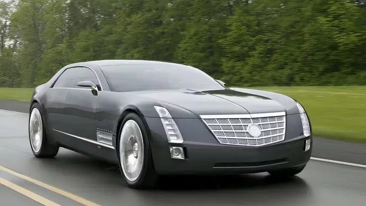 Cadillac Sixteen concept car - Engine Stories Sleek black luxury car driving down a wet road, surrounded by lush greenery, showcasing modern design and elegance.