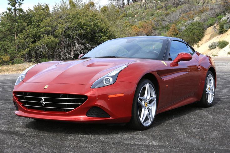 Red sports car parked on scenic road, showcasing sleek design and luxury performance. Perfect for automotive enthusiasts.