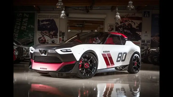 Nissan IDx Nismo Concept - Engine Stories Futuristic Nissan concept car in showroom, sleek design with bold graphics and sporty features, highlighted under bright lights.