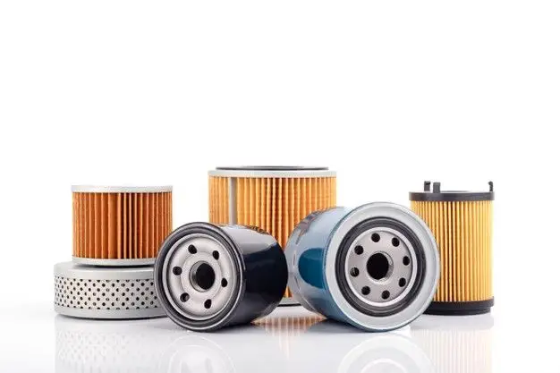 Assorted car oil filters isolated on white background, featuring various sizes and types for vehicle maintenance.