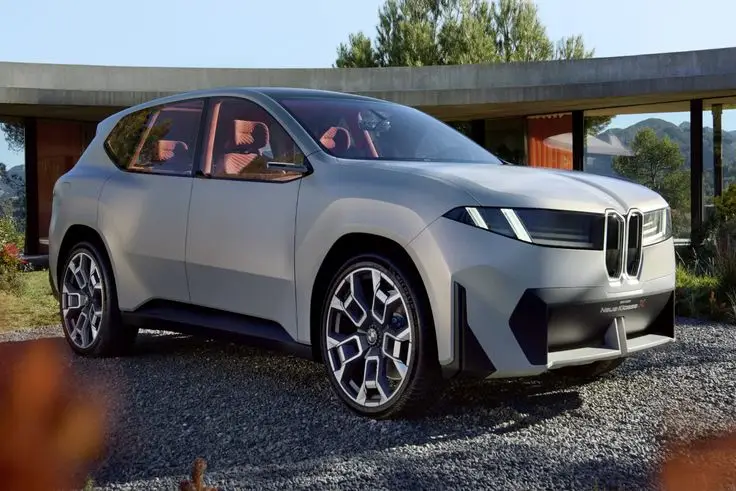 Futuristic SUV parked outdoors in front of a modern house, showcasing a sleek design and advanced features.