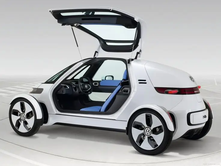 Futuristic white compact car with gullwing doors open, showcasing sleek design and modern features in an empty parking lot.