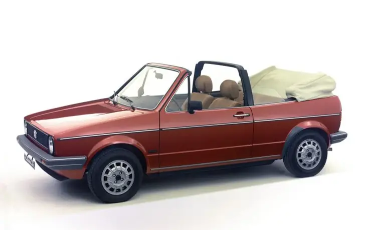 Volkswagen Golf Cabriolet 1979 - 1987_ - Engine Stories Red vintage convertible Volkswagen car with soft-top down, showcasing classic design on a plain background.