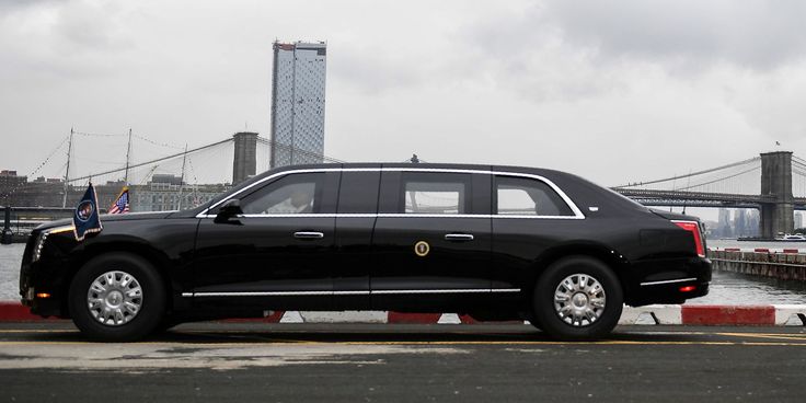 presidential CadillacsThe Beast - Engine Stories Black limousine parked near Brooklyn Bridge, cloudy sky, cityscape background.