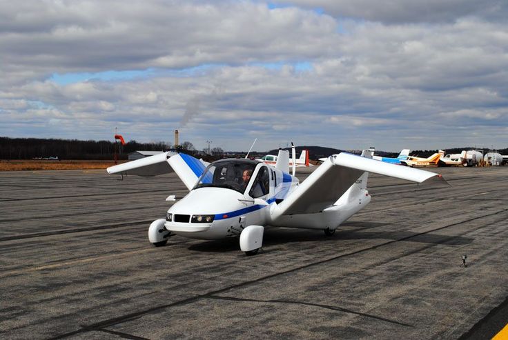 terrafugia transition flying car conducts first public flights - Engine Stories Futuristic flying car with extended wings parked on an airport runway, showcasing innovative transportation technology.