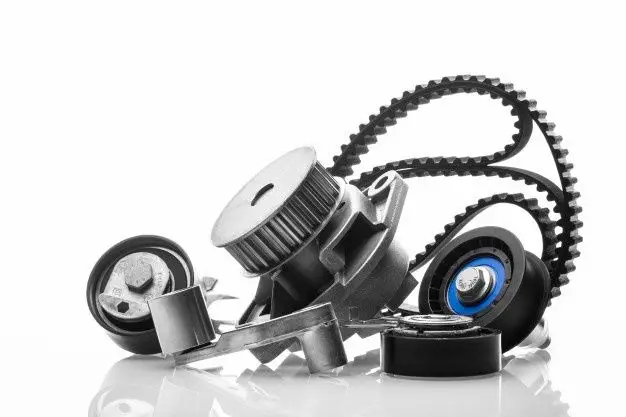 Close-up of automotive engine parts including timing belt and pulleys on white background, showcasing precision engineering.