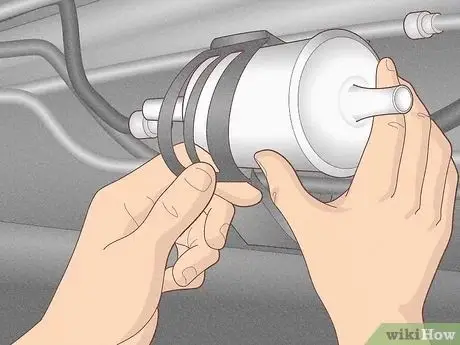 Hands installing a fuel filter into a car's fuel line system, ensuring efficient fuel flow for vehicle maintenance.