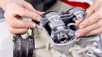 Mechanic adjusting camshaft components on an engine.