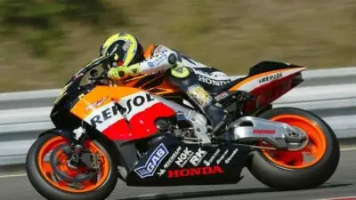 Motorcycle racer in action on a Repsol Honda bike, displaying speed and precision on the track.