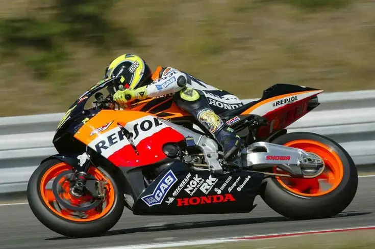 Motorcycle racer in action on a Repsol Honda bike, displaying speed and precision on the track.