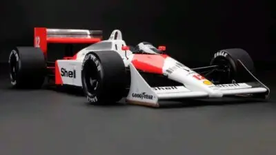 Classic Formula 1 race car with Goodyear tires, Shell branding, and striking red-white design, showcased against a dark backdrop.