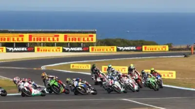 Motorcycles race on a coastal track at Phillip Island, with Pirelli signage in the background.