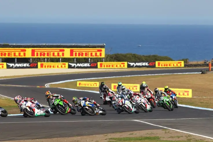 Motorcycles race on a coastal track at Phillip Island, with Pirelli signage in the background.