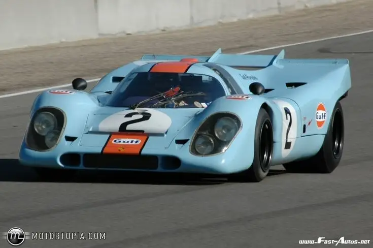 Vintage Gulf-liveried race car on track, showcasing classic design and speed in motorsport competition.